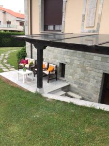 een patio met 2 banken en een tafel bij Apartamento independiente con jardín privado in Oviedo