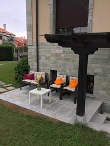 una chimenea con dos sofás y una mesa en Apartamento independiente con jardín privado, en Oviedo