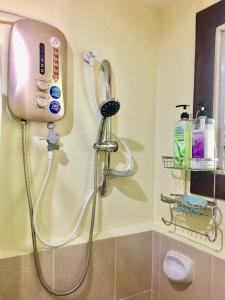 a shower in a bathroom with a phone on the wall at Johann’s Place Panglao in Panglao