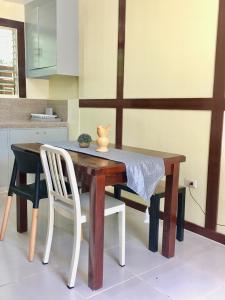 einem Esstisch mit einem weißen Stuhl und einem Tisch mit in der Unterkunft Johann’s Place Panglao in Panglao