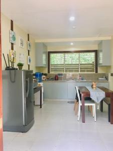 eine Küche mit einem Kühlschrank aus Edelstahl und einem Tisch in der Unterkunft Johann’s Place Panglao in Panglao