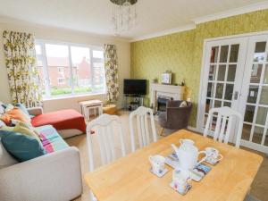 a living room with a table and a couch at Sea-u-Soon in Saltburn-by-the-Sea