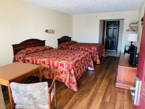 um quarto de hotel com duas camas e uma mesa em Landmark Inn em Sevierville