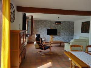 a living room with a couch and a tv at LA LOGIA DU SAULE in Rilly-la-Montagne