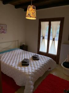 a bedroom with a white bed and two windows at Villa Argie in Néa Epídhavros