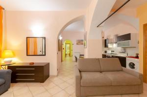 un soggiorno con divano e una cucina di JOIVY Warm Family Apt near Porto Antico a Genova