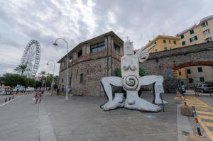 una statua di una persona che si trova di fronte a un edificio di JOIVY Warm Family Apt near Porto Antico a Genova