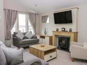 a living room with a fireplace and a tv at Cayton Pines in Scarborough