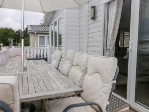 a wooden table and chairs on a porch with an umbrella at Cayton Pines in Scarborough