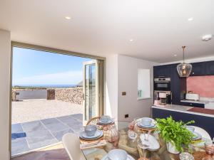 een keuken en eetkamer met uitzicht op het strand bij See Two Seas, Cape Cornwall in Penzance