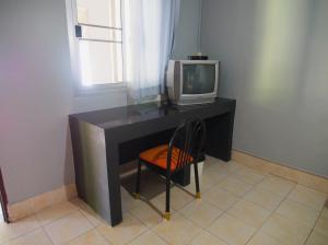 una scrivania con TV e una sedia in camera di Co Co House Samui a Mae Nam