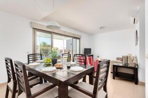 Un comedor con mesa y sillas de madera. en Villa 26, en Cala'n Bosch