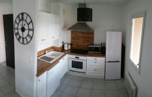 une cuisine avec des armoires blanches et un réfrigérateur blanc dans l'établissement Apt 50m2 avec Balcon tout équipé proche d'Avignon, à Pernes-les-Fontaines
