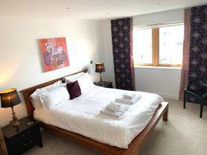- une chambre dotée d'un grand lit avec des draps et des oreillers blancs dans l'établissement 4-bedroom Penthouse - Fistral Beach, à Newquay