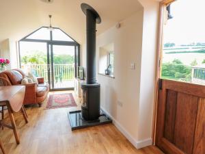 a wood stove in a living room with a table at The Hideout in Ross on Wye