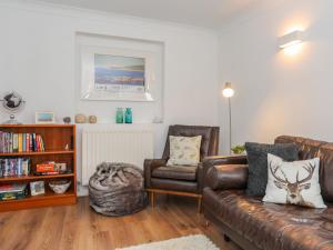 a living room with a couch and a chair at Cwtch Cottage in Rhosneigr