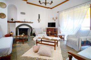 a living room with a couch and a fireplace at Villa Vasiliki in Paralía Avdhíron