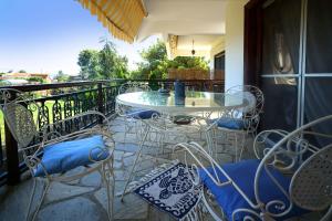 a patio with a table and chairs on a balcony at Villa Vasiliki in Paralía Avdhíron