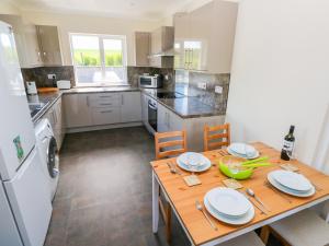 a kitchen with a wooden table with plates on it at Mill View in Milford Haven