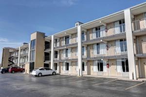 a large apartment building with cars parked in a parking lot at Fiddlers Inn Opryland in Nashville
