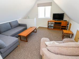 a living room with a couch and a tv at Mill View in Milford Haven
