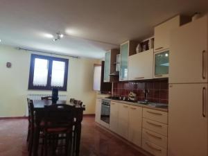 a kitchen with white cabinets and a table and chairs at La casa delle fate in Giave +19 photos