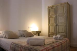 a bedroom with a bed with two towels on it at Weflating Sant Antoni Market in Barcelona