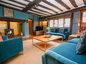 a living room with blue furniture and a fireplace at 3 Masons Court in Stratford-upon-Avon
