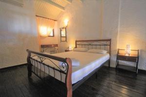 a bedroom with a bed and a night stand with a lamp at Delphi Hotel in Neo Klima
