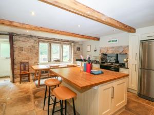 uma cozinha com um balcão de madeira num quarto em Bamforth Cottage em Holmfirth