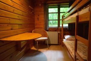 una habitación con una mesa y una cama en una cabaña en Bungalow; Haus 111 Ferienpark Twistesee, Bad Arolsen, en Bad Arolsen