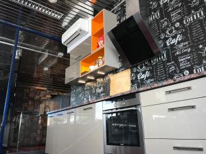 a kitchen with a black wall with a tv on it at Loft Car Factory in Warsaw