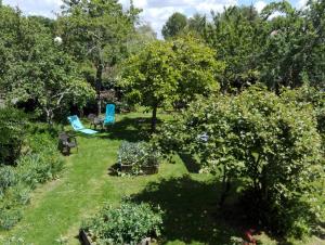 einen Garten mit Stühlen, Bäumen und Gras in der Unterkunft Gîte "Au Gré de l'Adour" in Aire-sur-lʼAdour