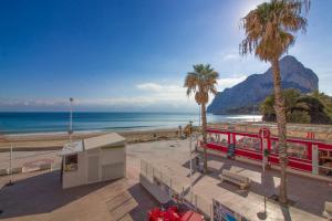 pociąg na plaży z palmami i oceanem w obiekcie Apartamento Calpe Mediterráneo 1º línea w mieście Calpe