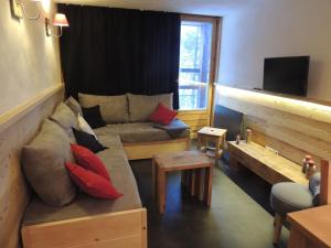 uma sala de estar com um sofá e uma televisão em LAUZIERE 1266/68 em Arc 1800