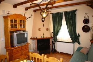 a living room with a couch and a television at Los Olivos in Arroyo Frio