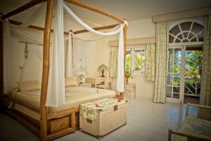 a bedroom with a bed and a canopy canopy at Hotel Villa Serena in Las Galeras