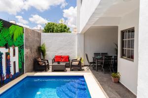a patio with a swimming pool and a table and chairs at Santa Fe Studios And Suites in Cancún