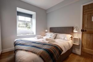 um quarto branco com uma cama grande e uma janela em The Farmhouse Llyn Peninsula em Pistyll