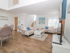 a living room with two couches and a tv at Waterside in Chathill