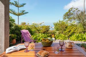 una mesa con un libro y copas de pan y vino en Quinta Devónia by An Island Apart, en Funchal
