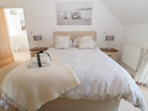 a bedroom with a large white bed with pillows at Waterside in Chathill