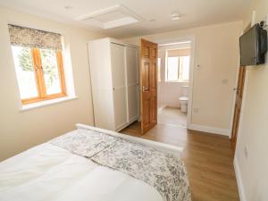 Cider Cottage في ستراتفورد أبون آفون: غرفة نوم بيضاء مع سرير وحمام