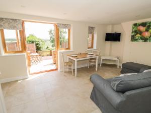 ein Wohnzimmer mit Sofa und Tisch in der Unterkunft Cider Cottage in Stratford-upon-Avon