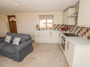 ein Wohnzimmer mit Couch und Küche in der Unterkunft Cider Cottage in Stratford-upon-Avon