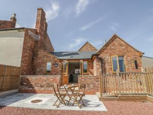 een stenen huis met twee stoelen ervoor bij Cider Cottage in Stratford-upon-Avon