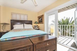a bedroom with a bed with a dresser and a balcony at Joyce's Beachfront Penthouse in Clearwater Beach +27 photos