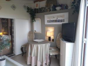 a dining room with a table and a tv at Apartamento con terraza y vistas al mar in Burriana