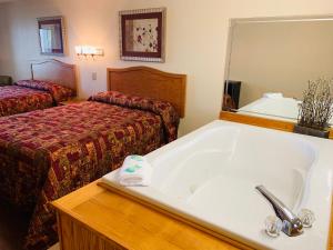 um quarto de hotel com uma banheira e uma cama em Landmark Inn em Sevierville