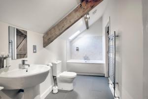 a white bathroom with a sink and a toilet at The Hay Barn - Llyn Peninsula in Nefyn